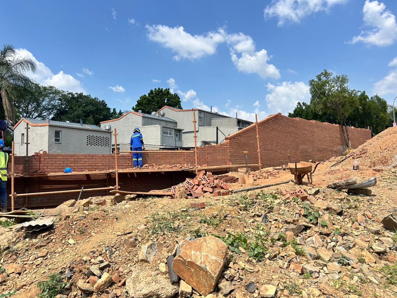 Construction site with workers laying bricks on scaffolding